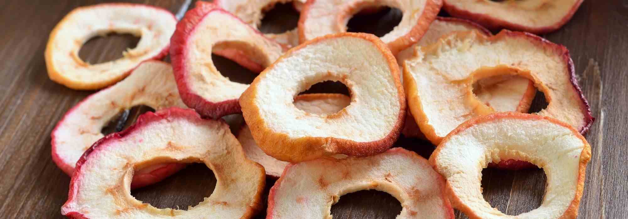 How to make dried apples (apple chips)

Ingredients and equipment
- Apples: choose crisp, firm varieties (Braeburn, Pink Lady, Cox, Granny Smith, Honeycrisp).
- Lemon juice or ascorbic acid (optional) to prevent browning.
- Sharp knife or mandoline, apple corer (optional).
- Dehydrator, oven, or air fryer; baking trays and cooling racks.

Preparation
1. Wash apples. Core apples if you prefer rings without seeds; peeling optional.
2. Slice apples uniformly, 2–5 mm thick for crisp chips, 5–8 mm for chewier slices. Use a mandoline for even thickness.
3. Prevent browning (optional): dip slices 2–5 minutes in a solution of 1 tablespoon lemon juice to 500 ml water or in a solution of vitamin C powder (ascorbic acid) per package instructions. Drain and pat slices dry.
4. Optional seasoning: sprinkle with ground cinnamon or a light dusting of sugar before drying.

Drying methods
- Dehydrator: arrange slices in a single layer, no overlap. Set at 55–63°C and dry 6–12 hours depending on thickness and variety. Check after 4–6 hours and rotate trays for even drying.
- Oven: place slices on baking trays or on racks to allow air circulation. Set oven to lowest possible temperature (ideally 80–100°C). Leave oven door slightly ajar to let moisture escape. Dry 2–4 hours for thin slices, longer for thicker slices. Turn slices halfway through.
- Air fryer: arrange in single layer, set to around 100–120°C and dry 20–60 minutes, checking and turning frequently to avoid burning.
- Sun-drying (UK climate not ideal): requires hot, dry, insect-proof conditions and several days; not recommended unless climate allows.

How to tell when ready
- Apple chips should be dry and flexible or crisp depending on target texture. They will crisp more as they cool. No visible wet spots or tackiness.
- For long-term storage aim for fully crisp slices.

Conditioning and storage
- Cool completely. Condition by placing cooled chips in a loosely sealed jar for 7–10 days, shaking daily to distribute any remaining moisture. If condensation appears, return to dehydrator/oven for further drying.
- Store in airtight containers in a cool, dark place. Well-dried apple chips keep several months; refrigeration or freezing extends shelf life.

Safety and tips
- Slice thickness and variety affect drying time and final texture.
- Avoid overcrowding trays to ensure even drying.
- Discard any slices showing mould or unpleasant odour.
- For flavoured chips, add spices before drying or toss dried chips with a little honey when warm for glazed finish.

Enjoy apple chips as a healthy snack, in muesli, or as a garnish for salads and desserts.